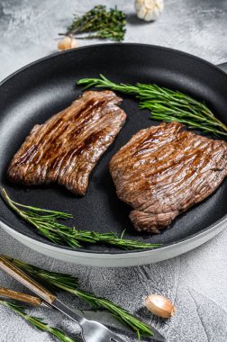 Kızarmış demir ve kanatlı biftekler. Mermer sığır eti. Gri arka plan. Üst görünüm.