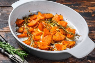 Ballı ve tarçınlı fırında pişmiş portakal kabağı dilimleri. Ahşap arka plan. Üst görünüm.