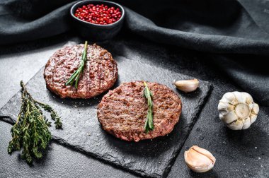 Izgara sığır burger köftesi. Et pirzolası. Siyah arka plan. Üst görünüm.