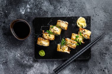 Füme yılan balığı ve salatalıklı suşi rulosu. Siyah arka plan. Üst görünüm.