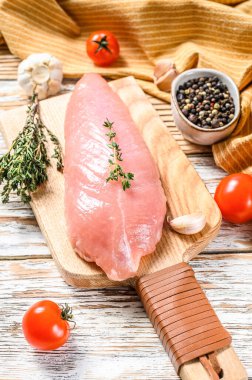 Çiğ hindi bifteği. Otlu göğüs filetosu. Beyaz ahşap arka plan. Üst görünüm.