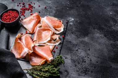 İtalyan jambonu, kekik ve jambonlu jambon. Siyah arka plan. Üst Manzara. Boşluğu kopyala.