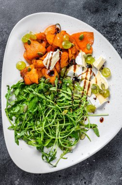 Izgara roka, ceviz ve peynirli sıcak salata. Siyah arka plan. Üst görünüm.