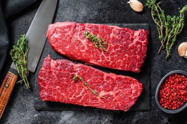 Denver bifteği ve şifalı bitkiler. Organik et. Siyah arka plan. Üst görünüm