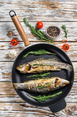 BBQ deniz levreği, tavada kızarmış levrek. Beyaz ahşap arka plan. Üst görünüm.