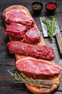 Çiğ siyah angus bifteği fileto Mignon, pirzola ya da kovboy, Striploin ya da New York, etek ya da pala. Ahşap arka plan. Üst görünüm.