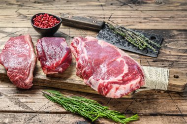 Taze çiğ siyah angus bifteği fileto Mignon, pirzola ya da kovboy, Striploin. Ahşap arka plan. Üst görünüm.