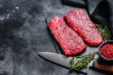 Denver bifteği ve şifalı bitkiler. Organik et. Siyah arka plan. Üst Manzara. Boşluğu kopyala.