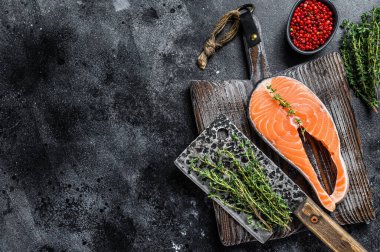 Biberli biftek şeklinde dilimlenmemiş somon balığı. Siyah arka plan. Üst Manzara. Boşluğu kopyala.