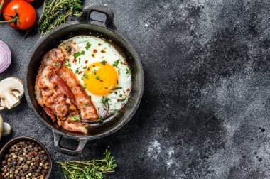 İngiliz kahvaltısı, kızarmış yumurta, domates, mantar, pastırma. Siyah arka plan. Üst Manzara. Boşluğu kopyala.