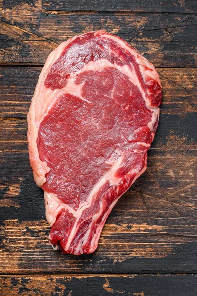 生牛仔或肋骨眼牛排在骨头上 牛肉肉馅易碎 深色木制背景 顶部视图 — 图库照片
