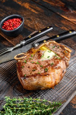 Izgara Biftek ya da kemik üzerinde çizgili biftek. Koyu ahşap arka plan. Üst görünüm.