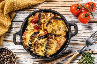 Dökme demir tabakta pişirilmiş sebzeli ratatouille. Ahşap arka plan. Üst görünüm.