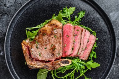 Az pişmiş ızgara biftekli biftek. Siyah arka plan. Üst görünüm.