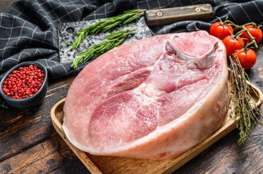 Çiğ domuz budu, bacağı kesme tahtasının üzerinde. Taze çiftlik eti. Ahşap arka plan. Üst görünüm