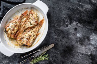 Kızıl Deniz levreği ya da pişirme kabında pişirilmiş bir orfoz. Siyah arka plan. Üst Manzara. Boşluğu kopyala.