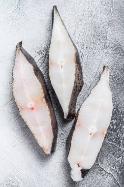 Taş masada çiğ taze balık halibut. Beyaz arka plan. Üst görünüm.