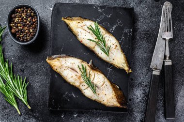 Fırında balık bifteği. Siyah arka plan. Üst görünüm.