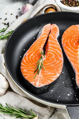 Tavada taze somon bifteği. Sağlıklı deniz ürünleri. Gri arka plan. Üst görünüm.