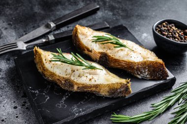 Fırında balık bifteği. Siyah arka plan. Üst görünüm.