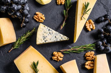 Farklı çeşit lezzetli peynirler, cevizler ve üzümlerle donatılmış güzel bir arka plan. Üst görünüm.