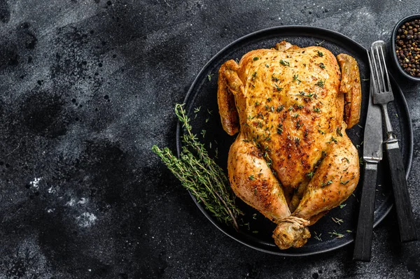 Ev yapımı kekikli fırınlanmış tavuk rostosu. Siyah arka plan. Üst Manzara. Boşluğu kopyala.
