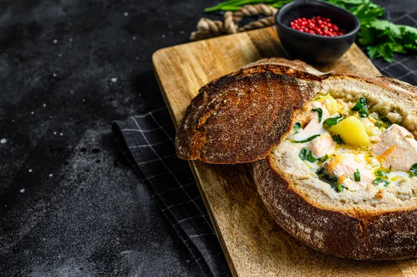 Finnish Creamy fish soup with salmon, trout, potatoes served in bread. Black background, top view, space for text. — Stock Image Finnish Creamy Fish Soup Salmon Trout Potatoes Served Bread Black Stock Picture