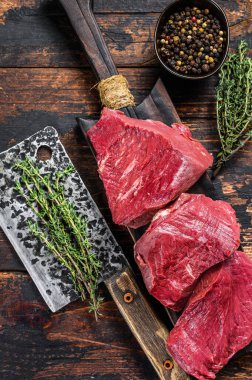 Kesme tahtasındaki çiğ karaciğer sakatatı. Koyu ahşap arka plan. Üst görünüm.