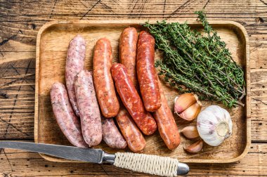 Çiğ sosis varyasyonu, sığır eti ve domuz eti. Ahşap arka plan. Üst görünüm.