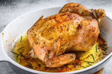 Seramik bir tabakta servis edilen lezzetli pişmiş, çıtır tavuk. Beyaz arka plan. Üst görünüm.