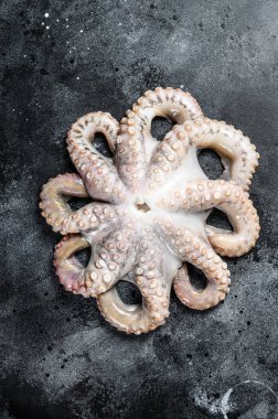Masada taze çiğ ahtapot var. Siyah arka plan. Üst görünüm.