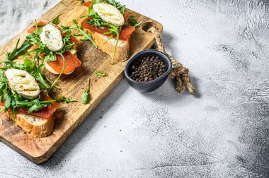 Keçi peynirli bruschetta, roka ve armut reçeli. Gri arka plan. Üst Manzara. Boşluğu kopyala.