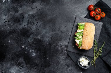 Taze peynirli Ciabatta sandviçi, armut reçeli ve roka. Siyah arka plan. Üst Manzara. Metin için boşluk.