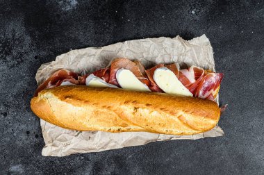 Jamon jambonlu sandviç, paleta iberica, Camembert peyniri. Siyah arkaplan, üst görünüm