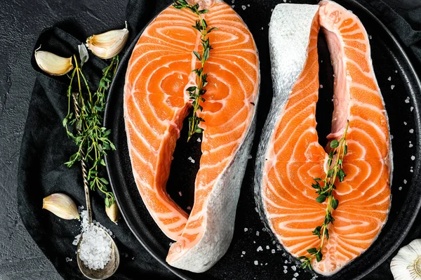 Baharatlı tabakta çiğ somon bifteği. Atlantik balığı. Siyah arka plan. Üst görünüm.