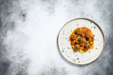 Domates soslu kıymadan yapılmış lezzetli köfteler, eski metal tavada servis ediliyor. Gri arka plan. Üst Manzara. Metin için boşluk.