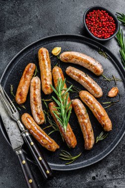 Biberiye, sığır eti ve domuz etiyle ızgara sosis. Siyah arka plan. Üst görünüm.