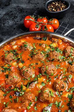 Domates soslu köfte ve tavada sebze. Siyah arka plan. Üst görünüm.