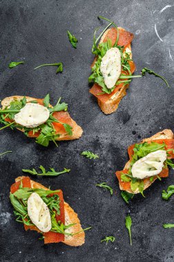 Keçi peynirli bruschetta, roka ve armut reçeli. Siyah arka plan. Üst görünüm.