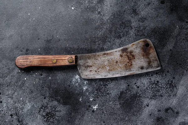 Vintage butcher cleaver with wooden handle. Black background. Top view.