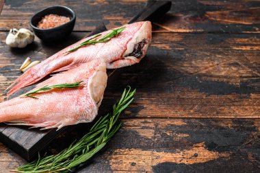 Taze taze kırmızı levrek ya da deniz kabuğu balığı. Koyu ahşap arka plan. Üst Manzara. Boşluğu kopyala.