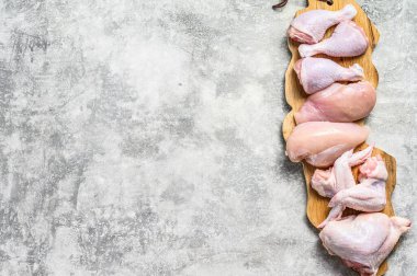 Kesme tahtasında çiğ tavuk eti. Gri arka plan. Üst Manzara. Boşluğu kopyala.