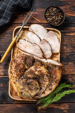 Kızarmış domuz jambonu. Saplanmış et. Koyu ahşap arka plan. Üst görünüm.