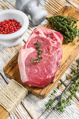 Çiğ et kulübü ya da bifteğin üzerinde çizgili et. Beyaz ahşap arka plan. Üst Manzara. Boşluğu kopyala.