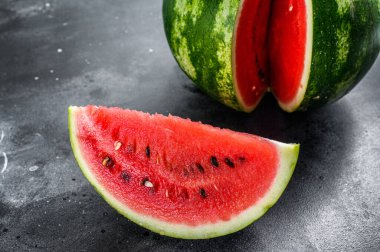 Kesilmiş dilimli, olgun kırmızı karpuz. Siyah arka plan. Üst görünüm.