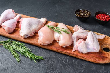 Taze çiğ tavuk eti ve tavuk parçaları. Siyah arka plan. Üst görünüm.