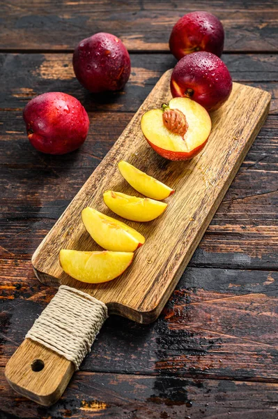 Cut nectarines on a wooden cutting Board. Wooden background. Top view.