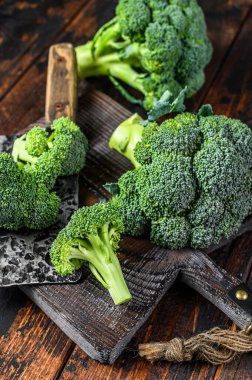 Kesme tahtasındaki çiğ brokoli. Koyu ahşap arka plan. Üst görünüm.