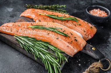 Tuzlu somon ya da baharatlı ve otlu alabalık filetosu. Siyah ahşap arka plan. Üst görünüm.