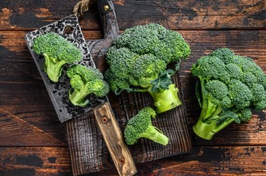 Kesme tahtasındaki çiğ brokoli. Koyu ahşap arka plan. Üst görünüm.